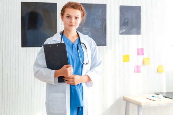 Une jeune femme médecin de garde en blouse blanche et stéthoscope tenant un dossier médical.